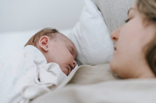 mother sleeping with newborn baby in bedroom